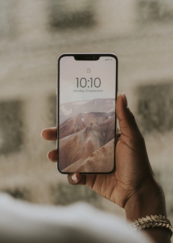 Hand holding smartphone by the window mockup