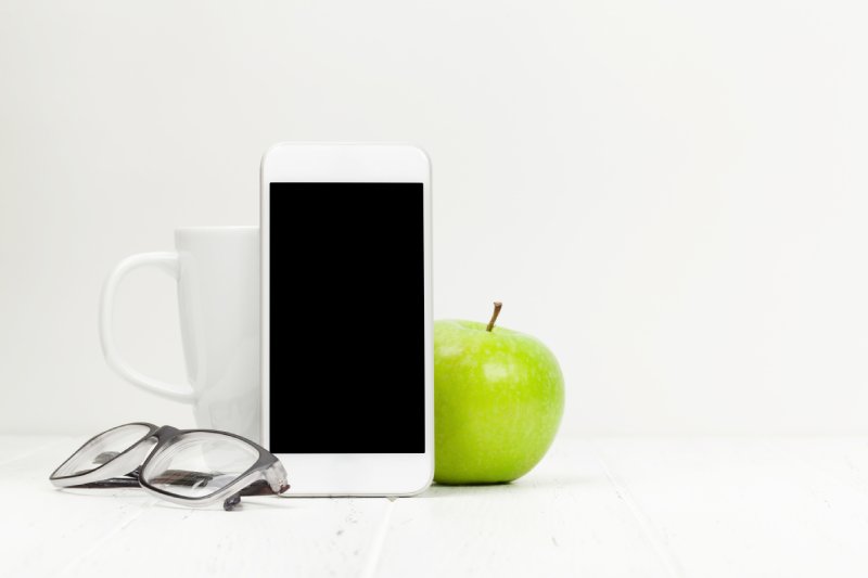 Workplace with smartphone, coffee and apple